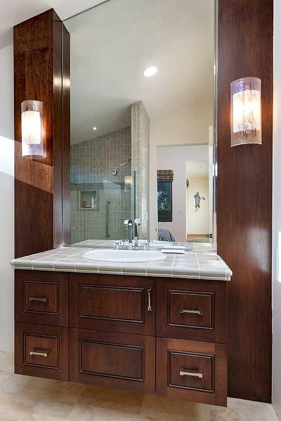 bathroom featuring vaulted ceiling, vanity, and a tile shower