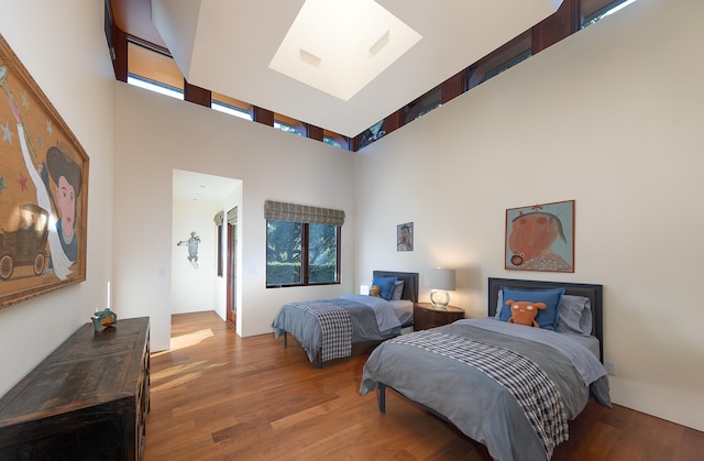 bedroom featuring a high ceiling and wood-type flooring