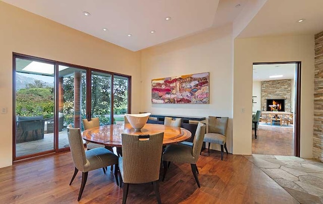 dining space with a fireplace and hardwood / wood-style floors