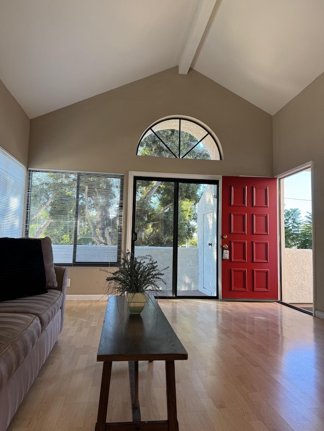 living room featuring beam ceiling, high vaulted ceiling, and light hardwood / wood-style flooring