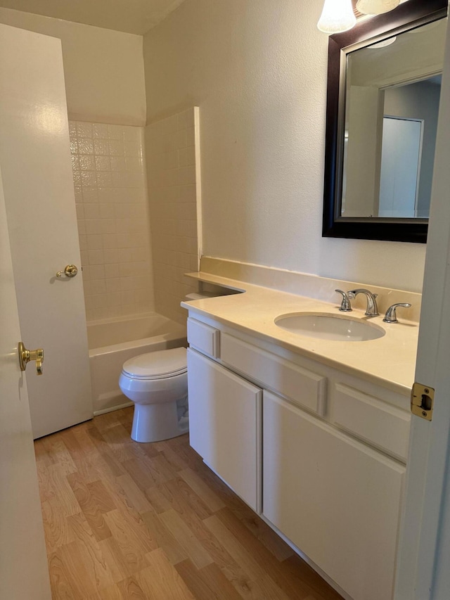 full bathroom featuring vanity, hardwood / wood-style flooring, toilet, and  shower combination