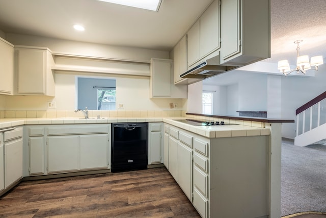 kitchen featuring kitchen peninsula, black appliances, dark hardwood / wood-style flooring, and a healthy amount of sunlight