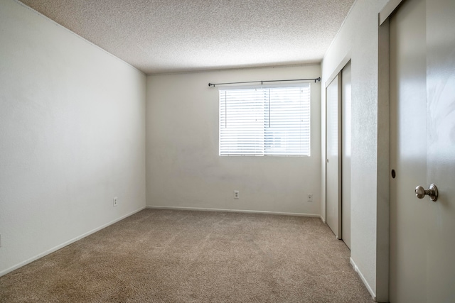 carpeted spare room featuring a textured ceiling