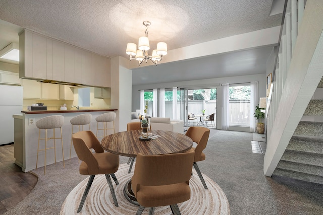 dining room featuring hardwood / wood-style flooring, a notable chandelier, and a textured ceiling