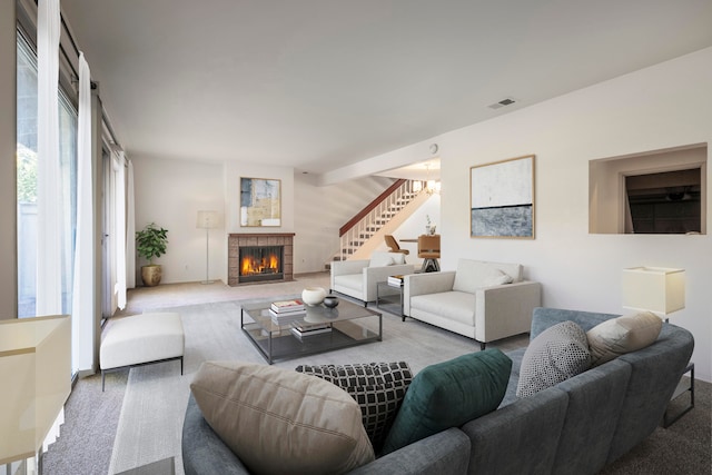 living room with light carpet and a tiled fireplace