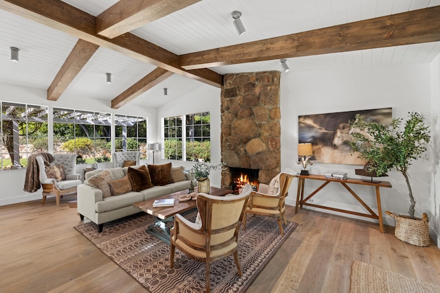 living room with vaulted ceiling with beams, light hardwood / wood-style flooring, a fireplace, and wooden ceiling