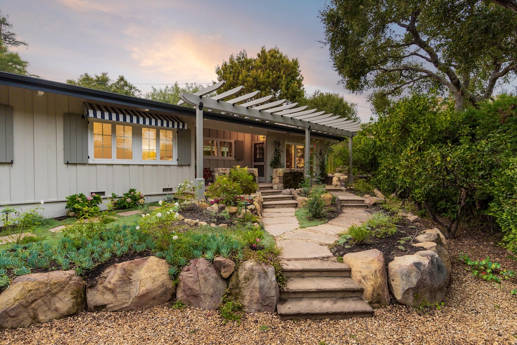 back house at dusk featuring a pergola