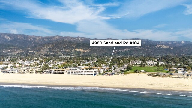 view of mountain feature featuring a water view and a view of the beach