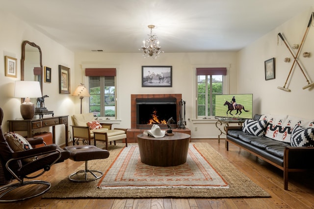 living room featuring a notable chandelier, light hardwood / wood-style floors, and a fireplace