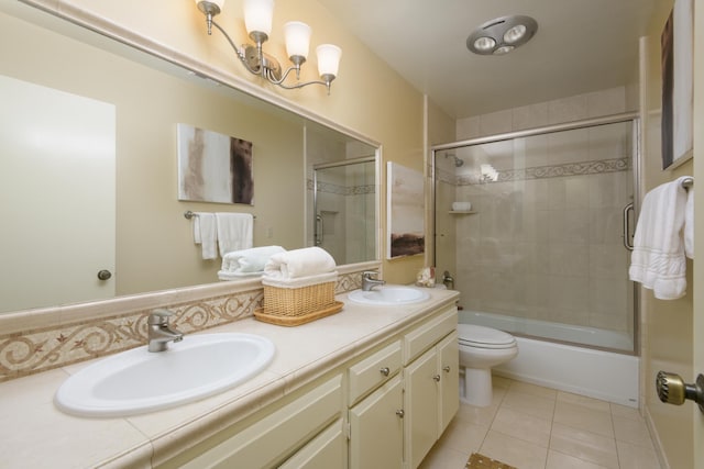 full bathroom with shower / bath combination with glass door, tile patterned floors, vanity, and toilet