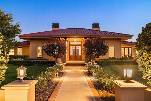 view of front of home featuring french doors and a yard