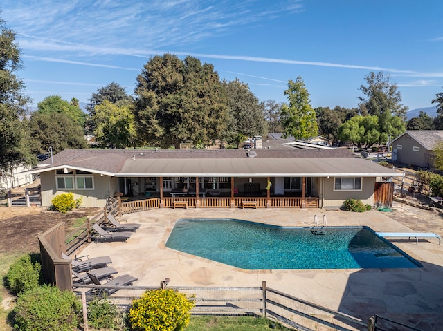 view of swimming pool with a patio and a diving board