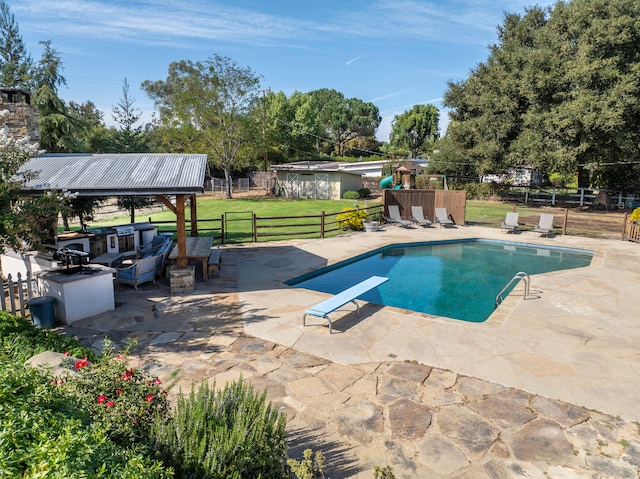 view of pool featuring a patio, a yard, and a diving board