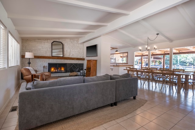 living room featuring a stone fireplace, a healthy amount of sunlight, lofted ceiling with beams, and light tile patterned floors