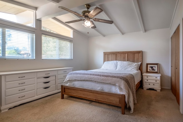 carpeted bedroom featuring vaulted ceiling with beams, a closet, and ceiling fan