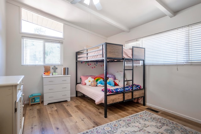 bedroom featuring ceiling fan, light hardwood / wood-style flooring, and vaulted ceiling with beams