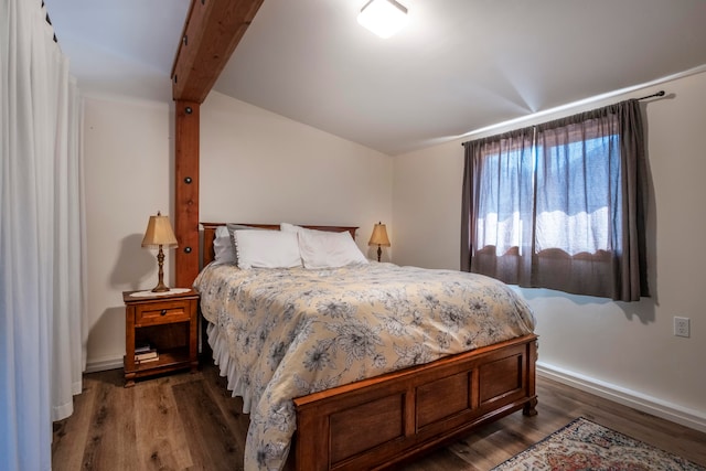 bedroom with beam ceiling and dark wood-type flooring