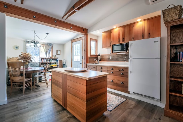 kitchen featuring a center island, lofted ceiling with beams, an inviting chandelier, white refrigerator, and dark hardwood / wood-style flooring