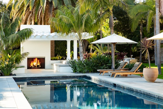 view of pool featuring a patio and an outdoor fireplace