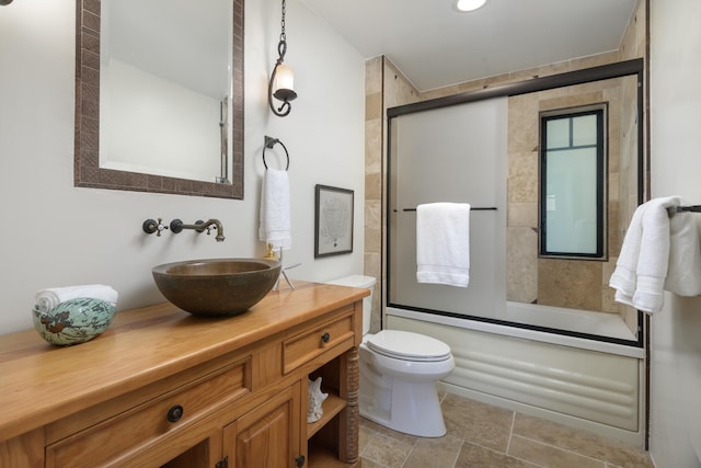 full bathroom featuring toilet, vanity, and shower / bath combination with glass door