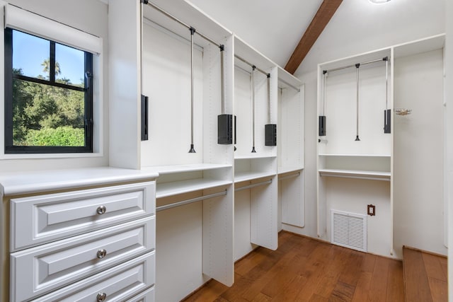 walk in closet with dark hardwood / wood-style floors and beamed ceiling