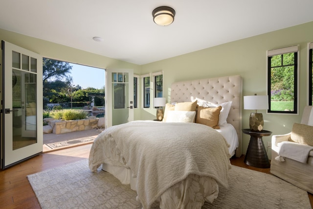 bedroom with access to outside and hardwood / wood-style floors