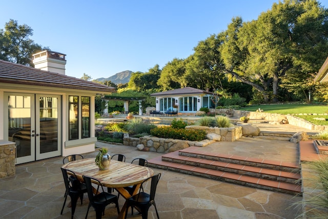 view of patio / terrace with french doors and a mountain view