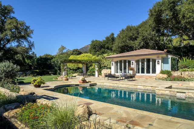 view of swimming pool with french doors and a patio