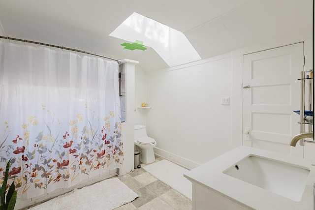 bathroom with vanity, toilet, walk in shower, and a skylight