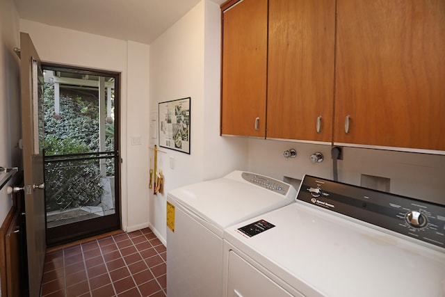 laundry room with cabinet space, dark tile patterned floors, baseboards, and separate washer and dryer