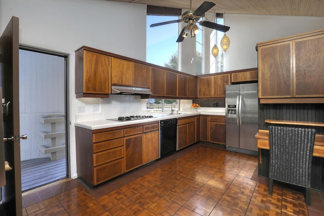 kitchen featuring black dishwasher, stainless steel fridge with ice dispenser, light countertops, under cabinet range hood, and gas cooktop