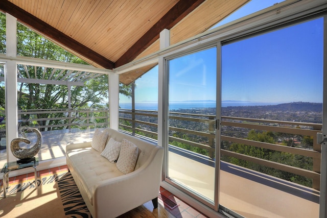 sunroom featuring lofted ceiling, wood ceiling, and plenty of natural light