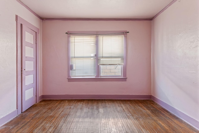 spare room featuring dark hardwood / wood-style flooring and crown molding