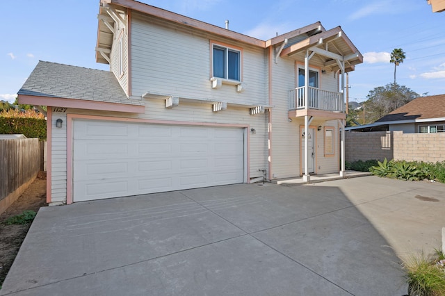 view of property featuring a garage and a balcony