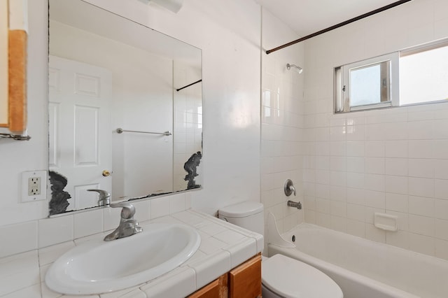 full bathroom featuring vanity, toilet, and tiled shower / bath