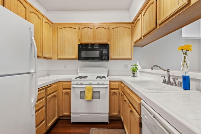 kitchen featuring white appliances, dark wood-type flooring, sink, and tile counters