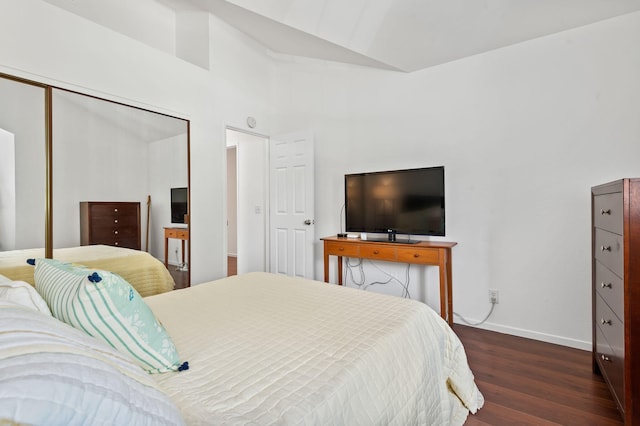 bedroom featuring a closet, vaulted ceiling, and dark hardwood / wood-style flooring