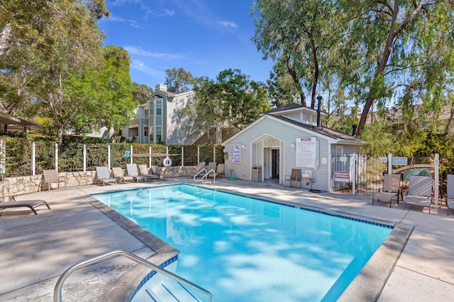 view of pool with a patio and an outbuilding