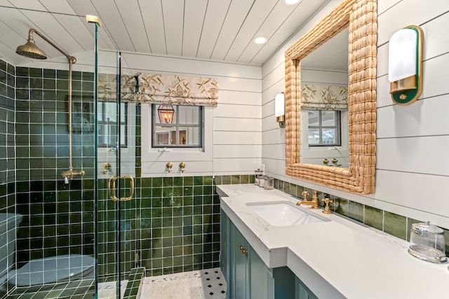 bathroom featuring vanity, walk in shower, and tile walls