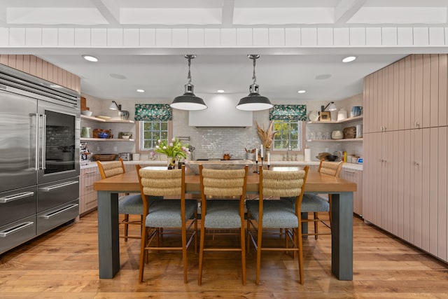 kitchen featuring built in fridge, light hardwood / wood-style floors, and plenty of natural light