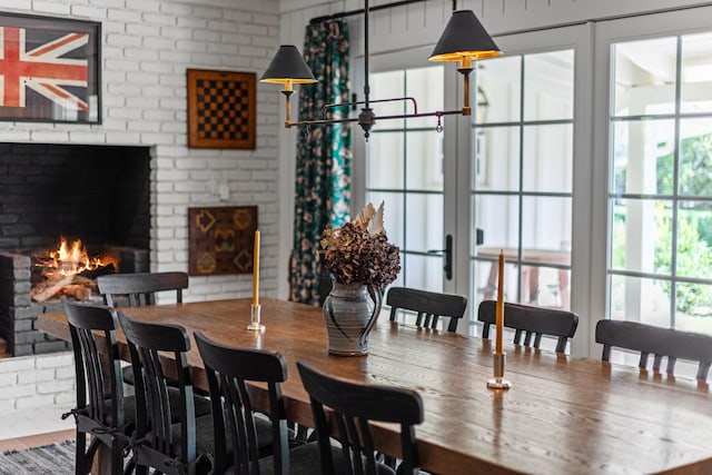 dining space featuring hardwood / wood-style floors, a fireplace, and a healthy amount of sunlight