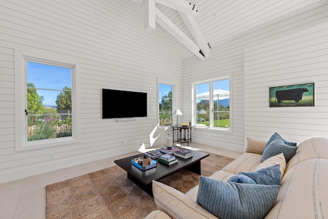 living room featuring beam ceiling, high vaulted ceiling, and wooden walls