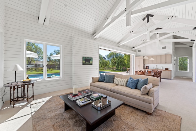 living room with wood walls, beam ceiling, and high vaulted ceiling