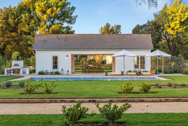 back of house featuring an outdoor structure, a yard, and a patio area