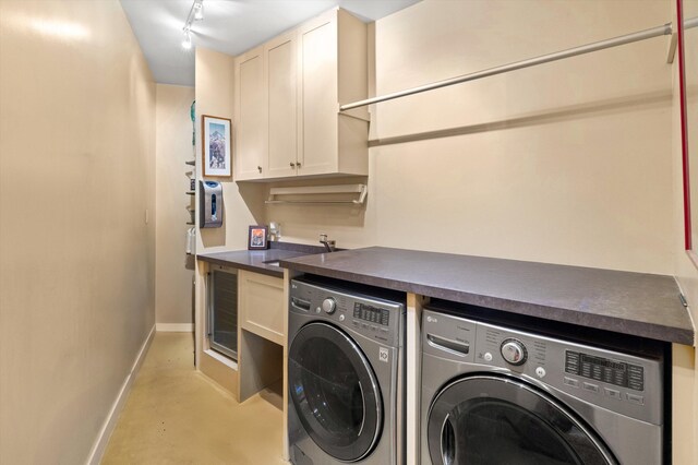 washroom featuring sink, rail lighting, cabinets, and independent washer and dryer