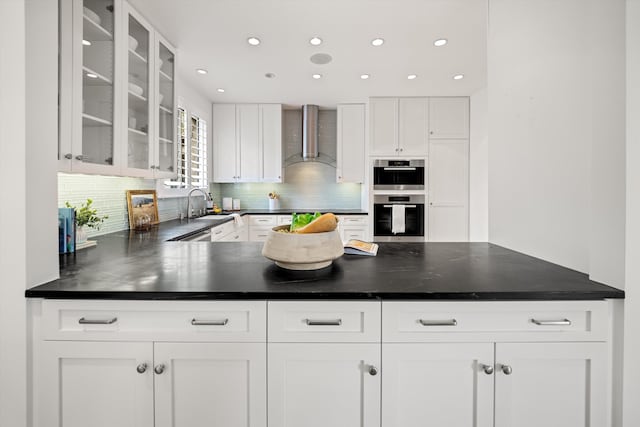 71 Seaview Dr, Santa Barbara, CA 93108 - kitchen featuring wall chimney range hood, double oven, decorative backsplash, glass insert cabinets, and a sink