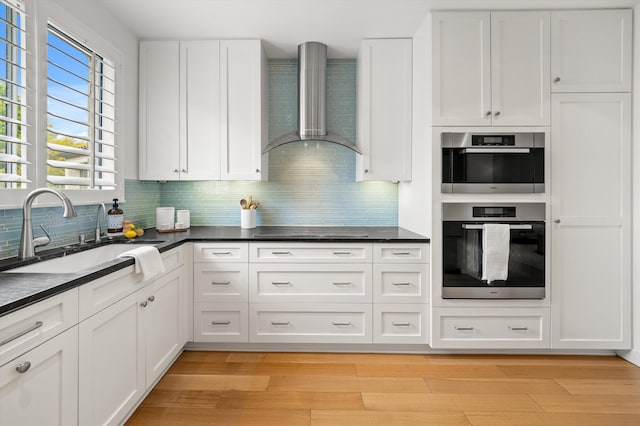71 Seaview Dr, Santa Barbara, CA 93108 - kitchen featuring wall chimney range hood, a sink, double oven, and dark countertops