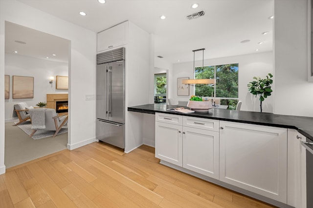 71 Seaview Dr, Santa Barbara, CA 93108 - kitchen featuring high quality fridge, white cabinets, a glass covered fireplace, dark countertops, and recessed lighting