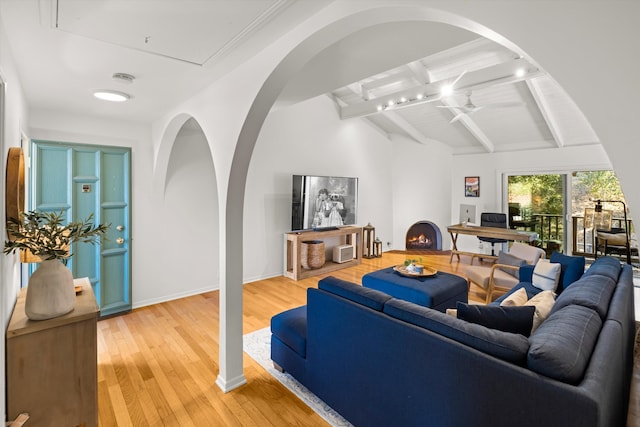 living room featuring vaulted ceiling with beams and hardwood / wood-style floors