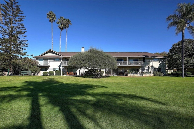 view of front of property with a front yard and a balcony